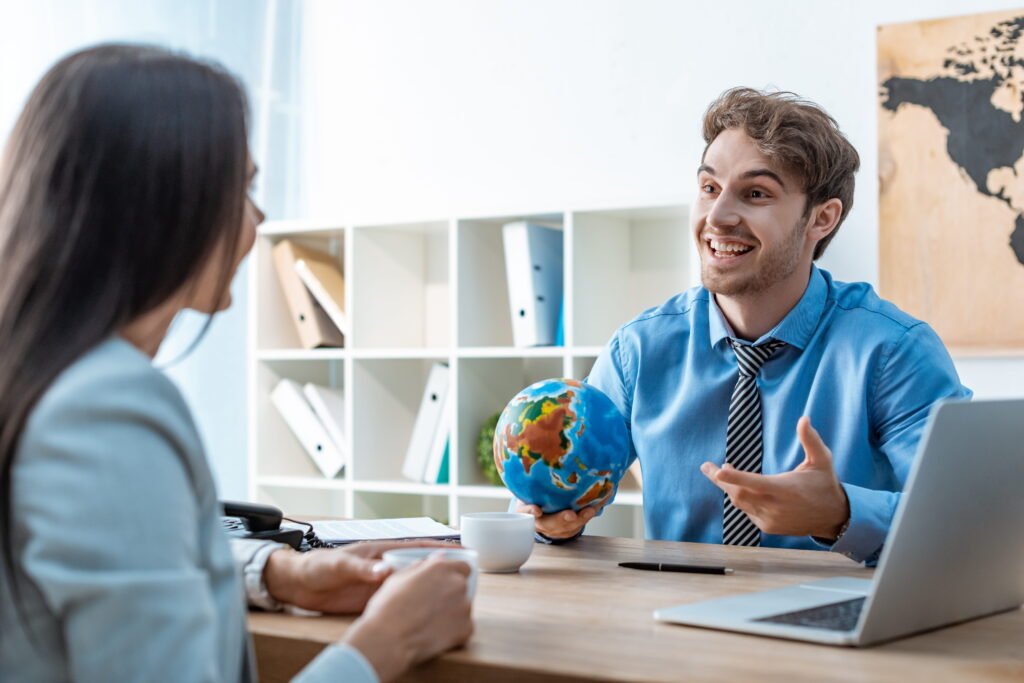 cheerful travel agent holding globe while talking 2026 01 09 12 22 17 utc 1